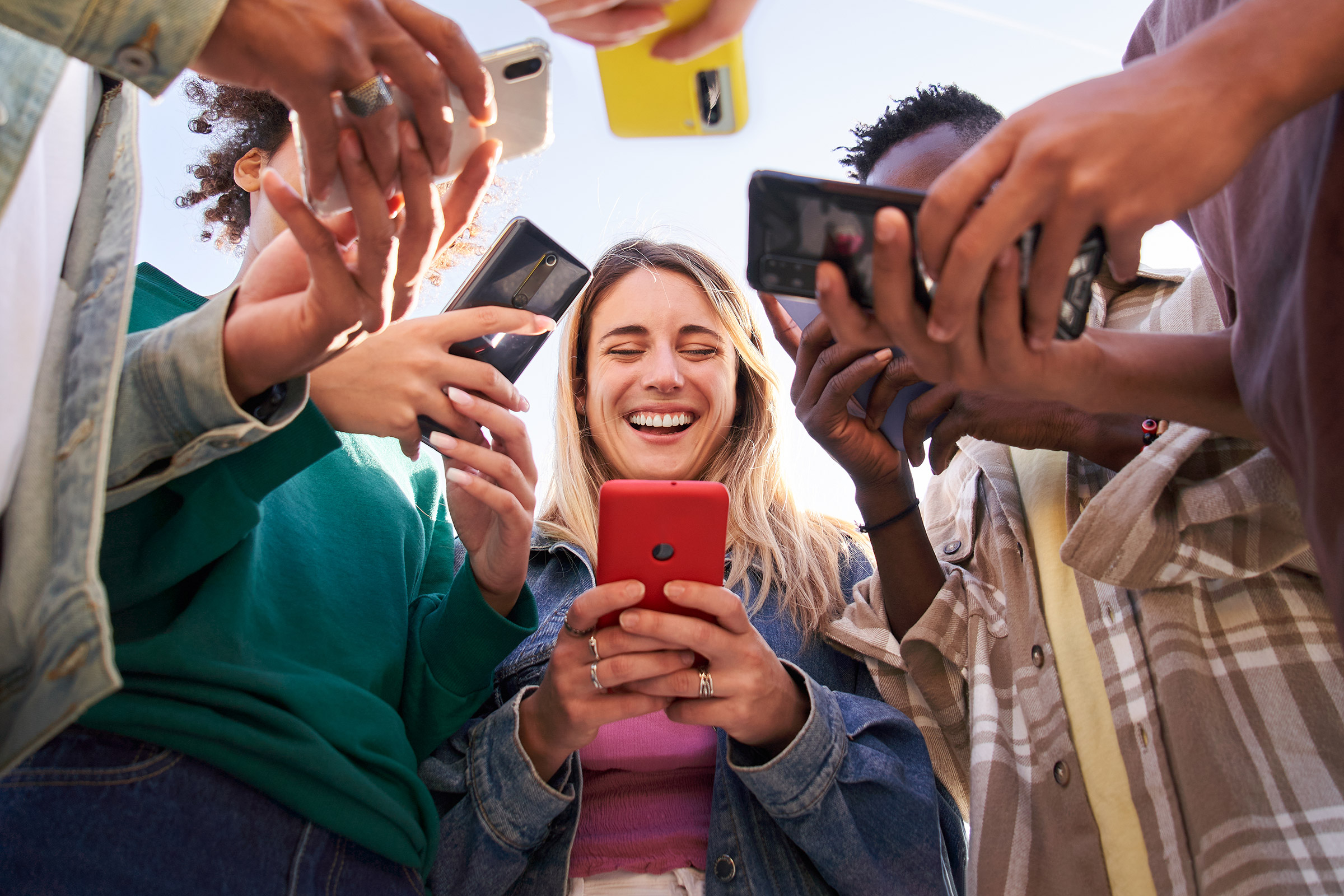 Teenagers in a group using their mobile phones