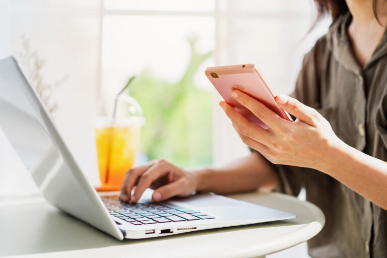 Woman working on laptop and smart phone